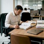 Un responsable passe en revue un dossier de conformité dans son bureau.