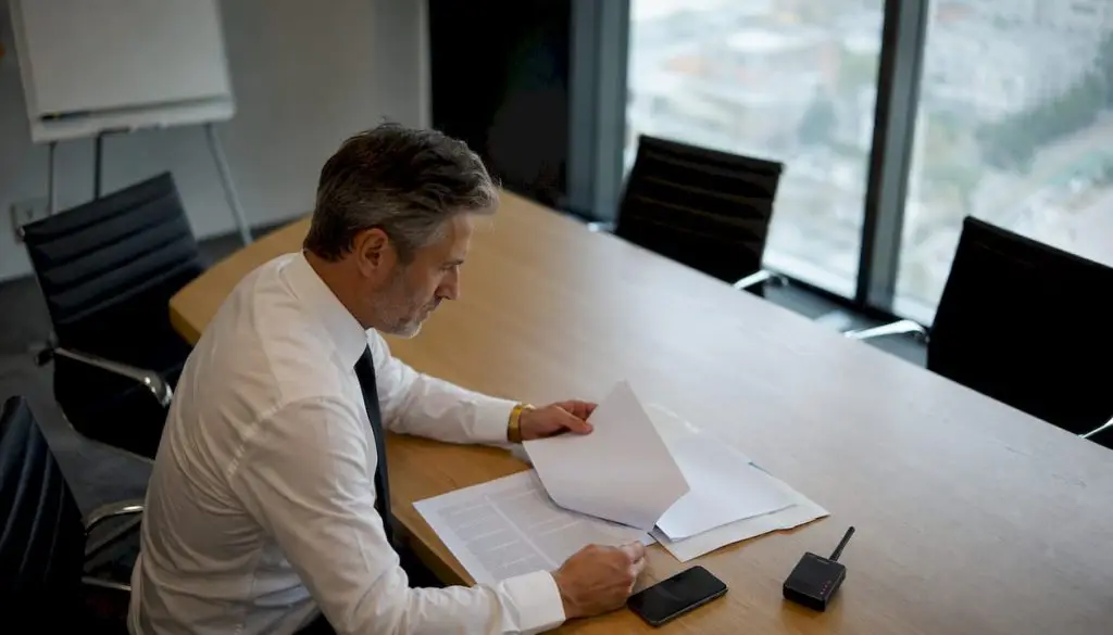 Dirigeant en bureau examinant smartphone