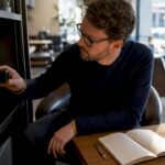 Un homme examine une caméra espion connectée au Wi-Fi dans un bureau.