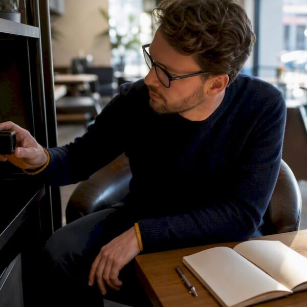 Un homme examine une caméra espion connectée au Wi-Fi dans un bureau.