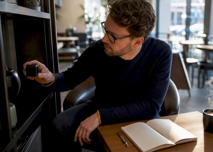 Un homme examine une caméra espion connectée au Wi-Fi dans un bureau.