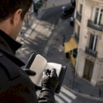 Un enquêteur prend des photos d’un immeuble afin de recueillir des éléments de preuve.